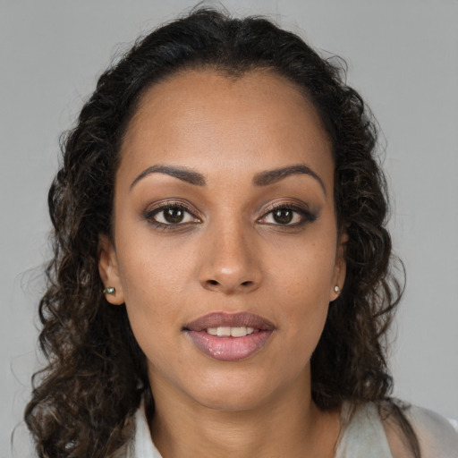 Joyful black young-adult female with long  brown hair and brown eyes