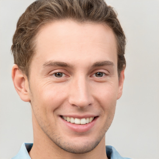 Joyful white young-adult male with short  brown hair and grey eyes