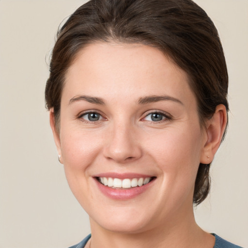 Joyful white young-adult female with short  brown hair and grey eyes