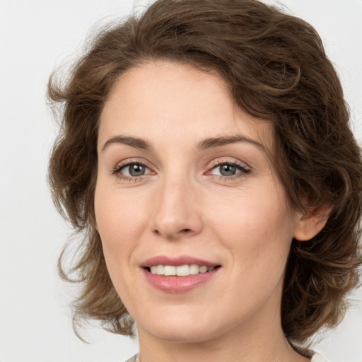 Joyful white young-adult female with medium  brown hair and green eyes