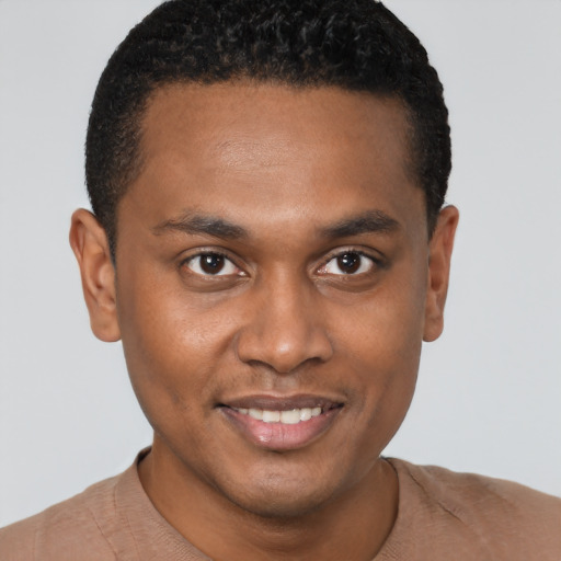 Joyful black young-adult male with short  brown hair and brown eyes