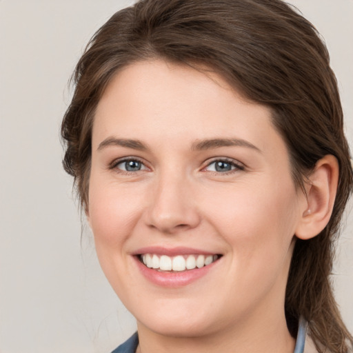 Joyful white young-adult female with medium  brown hair and grey eyes