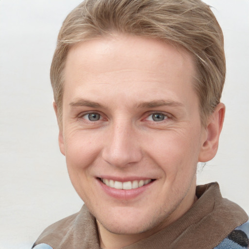 Joyful white young-adult female with short  brown hair and blue eyes