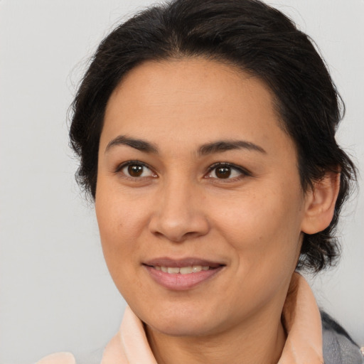 Joyful latino adult female with medium  brown hair and brown eyes