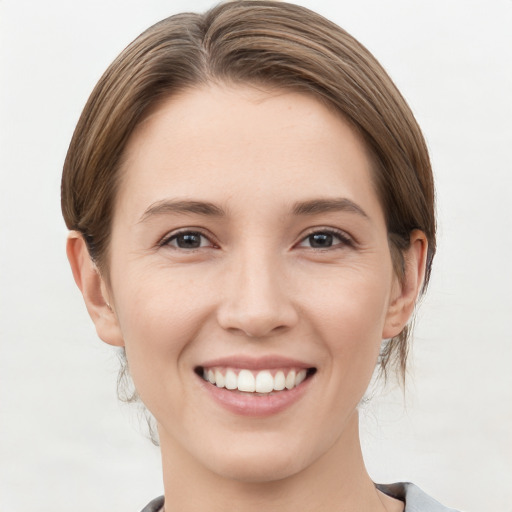 Joyful white young-adult female with medium  brown hair and grey eyes