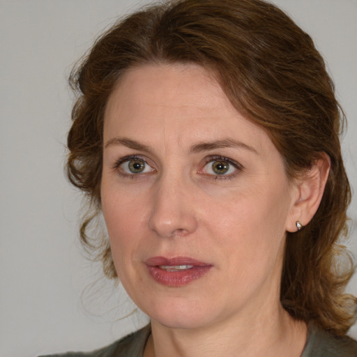 Joyful white adult female with medium  brown hair and green eyes