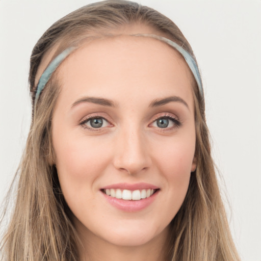 Joyful white young-adult female with long  brown hair and blue eyes