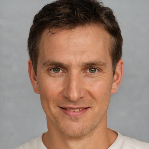 Joyful white adult male with short  brown hair and brown eyes