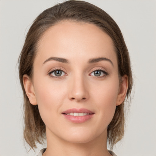 Joyful white young-adult female with medium  brown hair and grey eyes