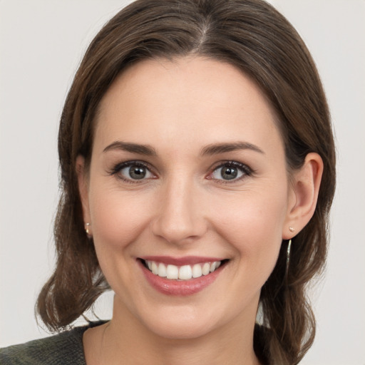 Joyful white young-adult female with medium  brown hair and grey eyes