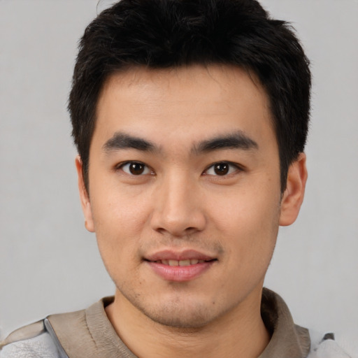 Joyful asian young-adult male with short  black hair and brown eyes