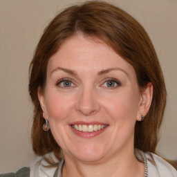 Joyful white adult female with medium  brown hair and blue eyes