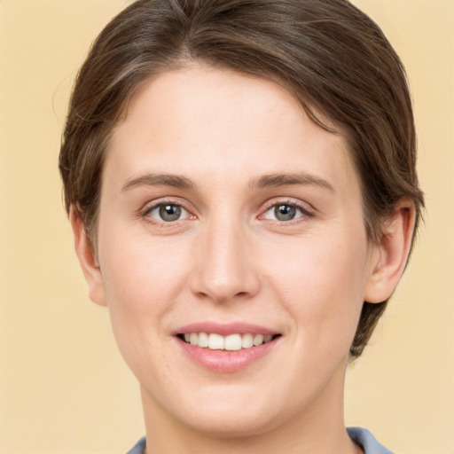 Joyful white young-adult female with short  brown hair and grey eyes