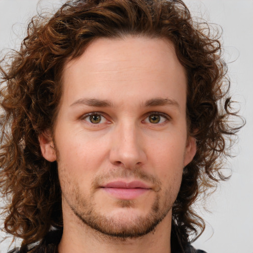 Joyful white young-adult male with long  brown hair and brown eyes