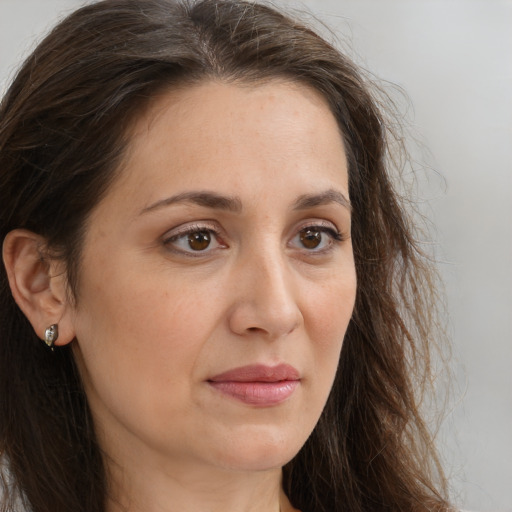 Joyful white adult female with long  brown hair and brown eyes