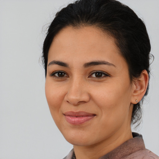 Joyful latino young-adult female with medium  brown hair and brown eyes