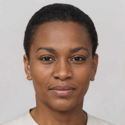 Joyful black young-adult female with short  black hair and brown eyes