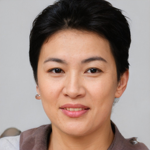 Joyful asian young-adult female with short  brown hair and brown eyes