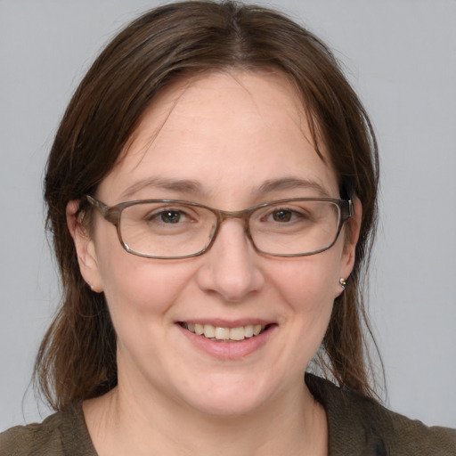 Joyful white adult female with medium  brown hair and blue eyes