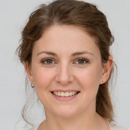 Joyful white young-adult female with medium  brown hair and grey eyes