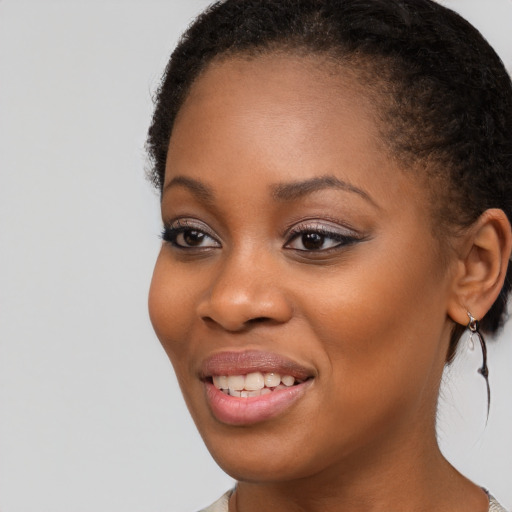 Joyful black young-adult female with long  brown hair and brown eyes
