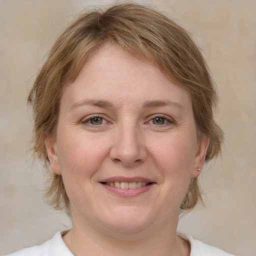 Joyful white adult female with medium  brown hair and green eyes