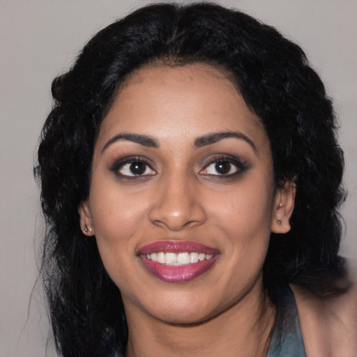 Joyful black young-adult female with long  black hair and brown eyes