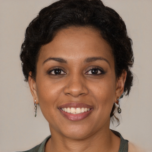 Joyful black young-adult female with short  brown hair and brown eyes