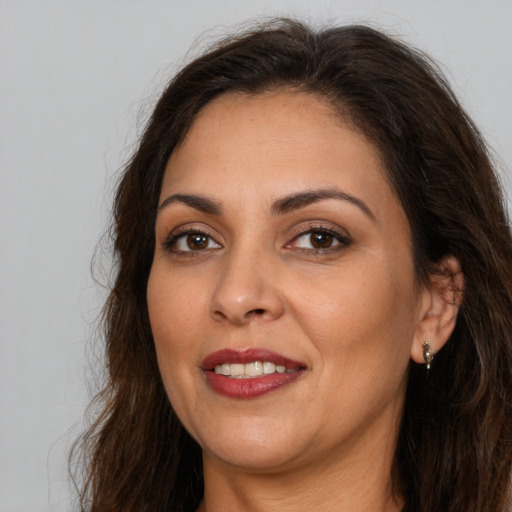 Joyful white adult female with long  brown hair and brown eyes