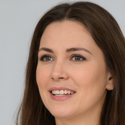 Joyful white young-adult female with long  brown hair and brown eyes