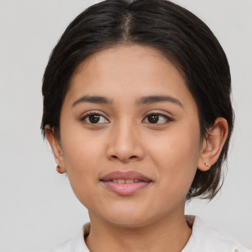 Joyful latino young-adult female with medium  brown hair and brown eyes