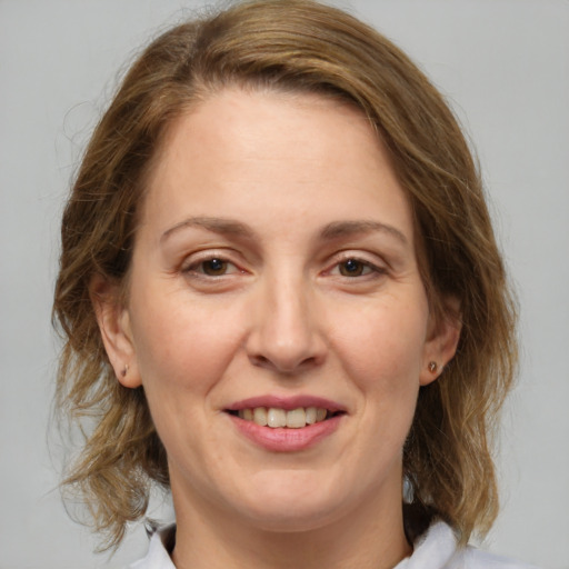 Joyful white adult female with medium  brown hair and brown eyes