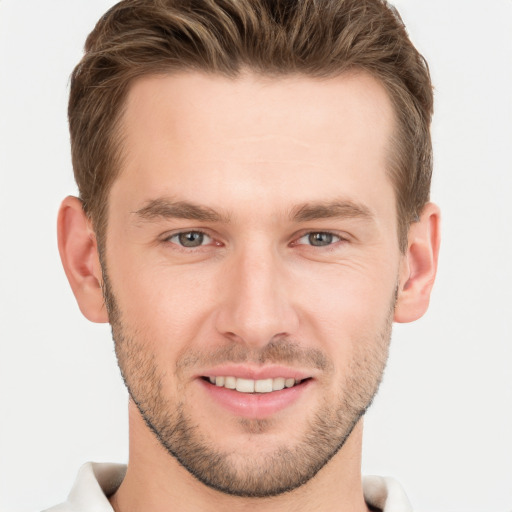 Joyful white young-adult male with short  brown hair and grey eyes