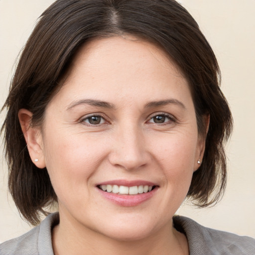 Joyful white young-adult female with medium  brown hair and brown eyes