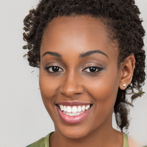 Joyful black young-adult female with long  brown hair and brown eyes