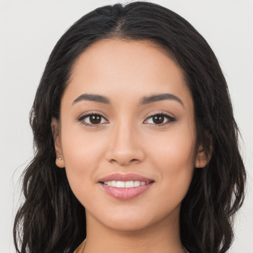 Joyful latino young-adult female with long  black hair and brown eyes