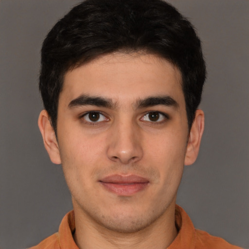 Joyful latino young-adult male with short  brown hair and brown eyes