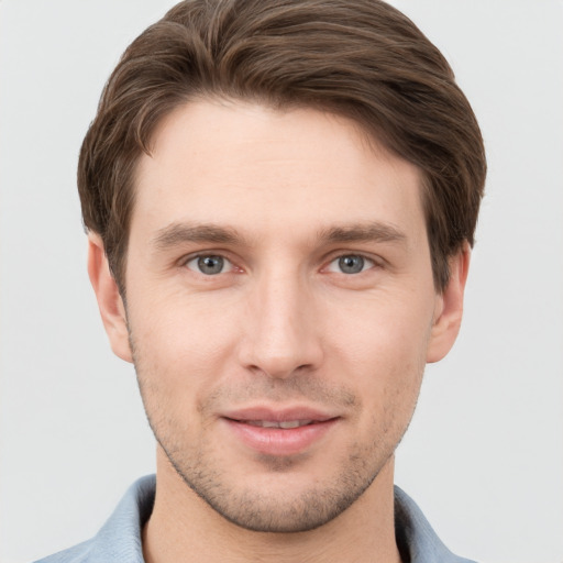 Joyful white young-adult male with short  brown hair and grey eyes