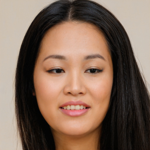 Joyful asian young-adult female with long  brown hair and brown eyes