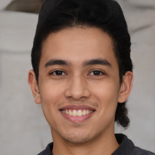 Joyful latino young-adult male with short  black hair and brown eyes