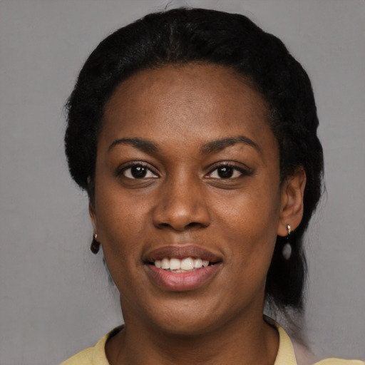 Joyful black young-adult female with short  black hair and brown eyes