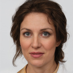 Joyful white adult female with medium  brown hair and grey eyes