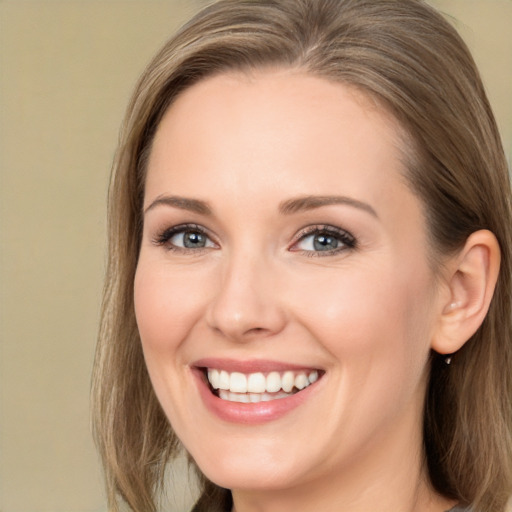 Joyful white young-adult female with long  brown hair and blue eyes