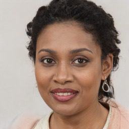 Joyful black young-adult female with long  brown hair and brown eyes