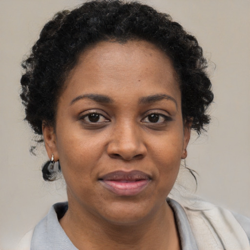 Joyful black adult female with short  brown hair and brown eyes