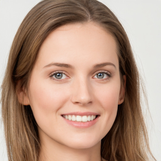 Joyful white young-adult female with long  brown hair and grey eyes