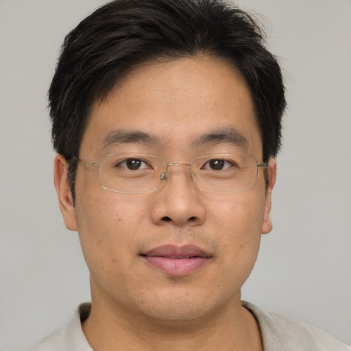 Joyful asian adult male with short  brown hair and brown eyes