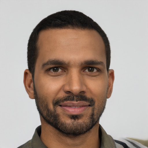 Joyful latino young-adult male with short  black hair and brown eyes