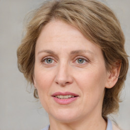 Joyful white adult female with medium  brown hair and blue eyes