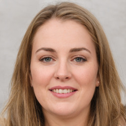 Joyful white young-adult female with long  brown hair and green eyes